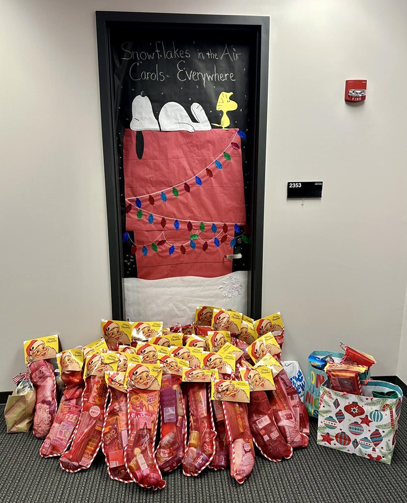 stuffed stockings in front of a door with Snoopy on his dog house