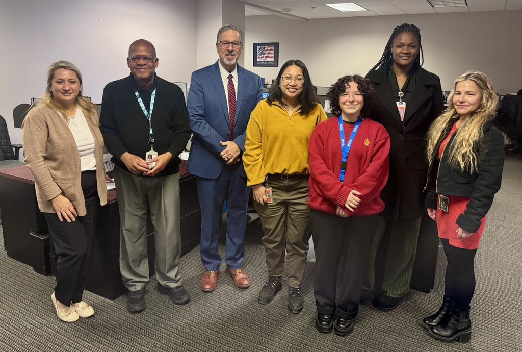Clerk Phillips standing with the staff of the Appeals Department in front of a desk